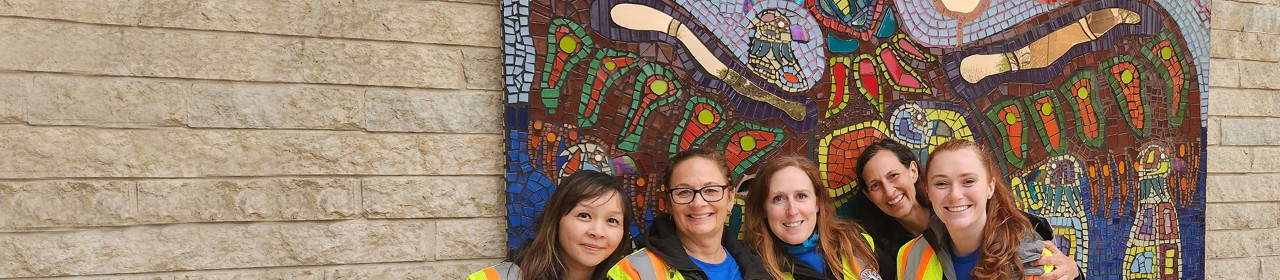Group of smiling women in front of a mosaic